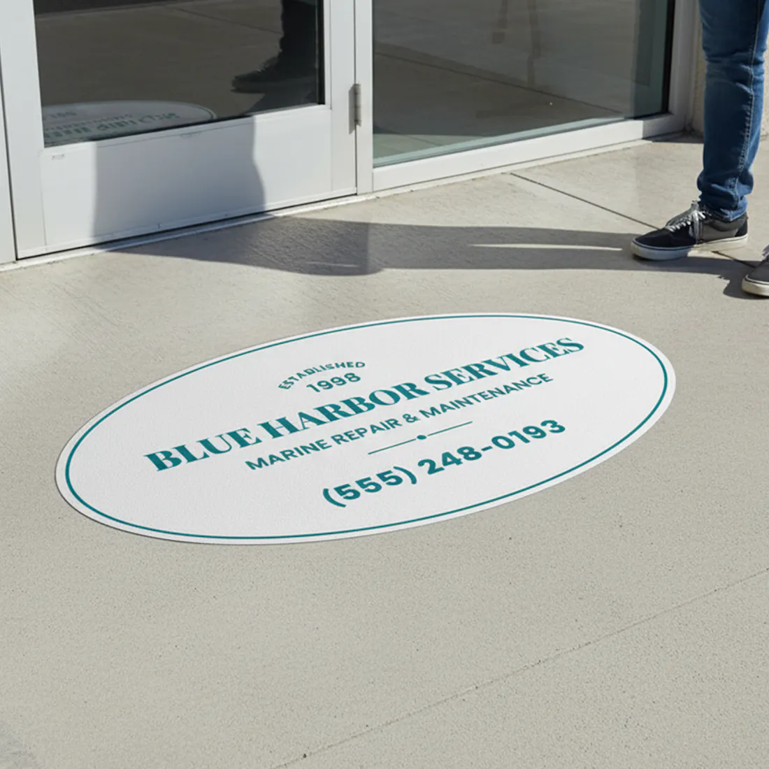 Oval floor mat with 'Blue Harbor Services' branding on a concrete floor.