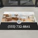 Real estate promotional mat with 'Silver Oak Realty Group' contact information on a floor.
